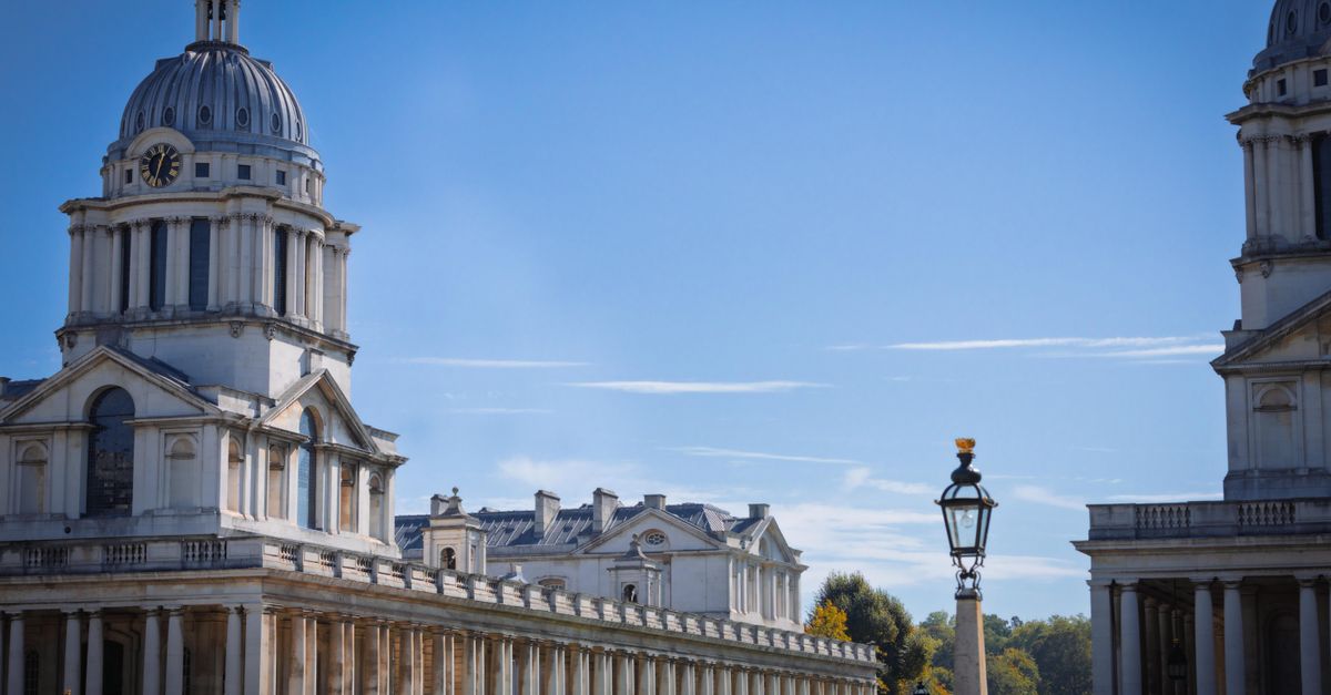 Iconic view of Old Royal Naval College in Greenwich, London under a clear sky.
